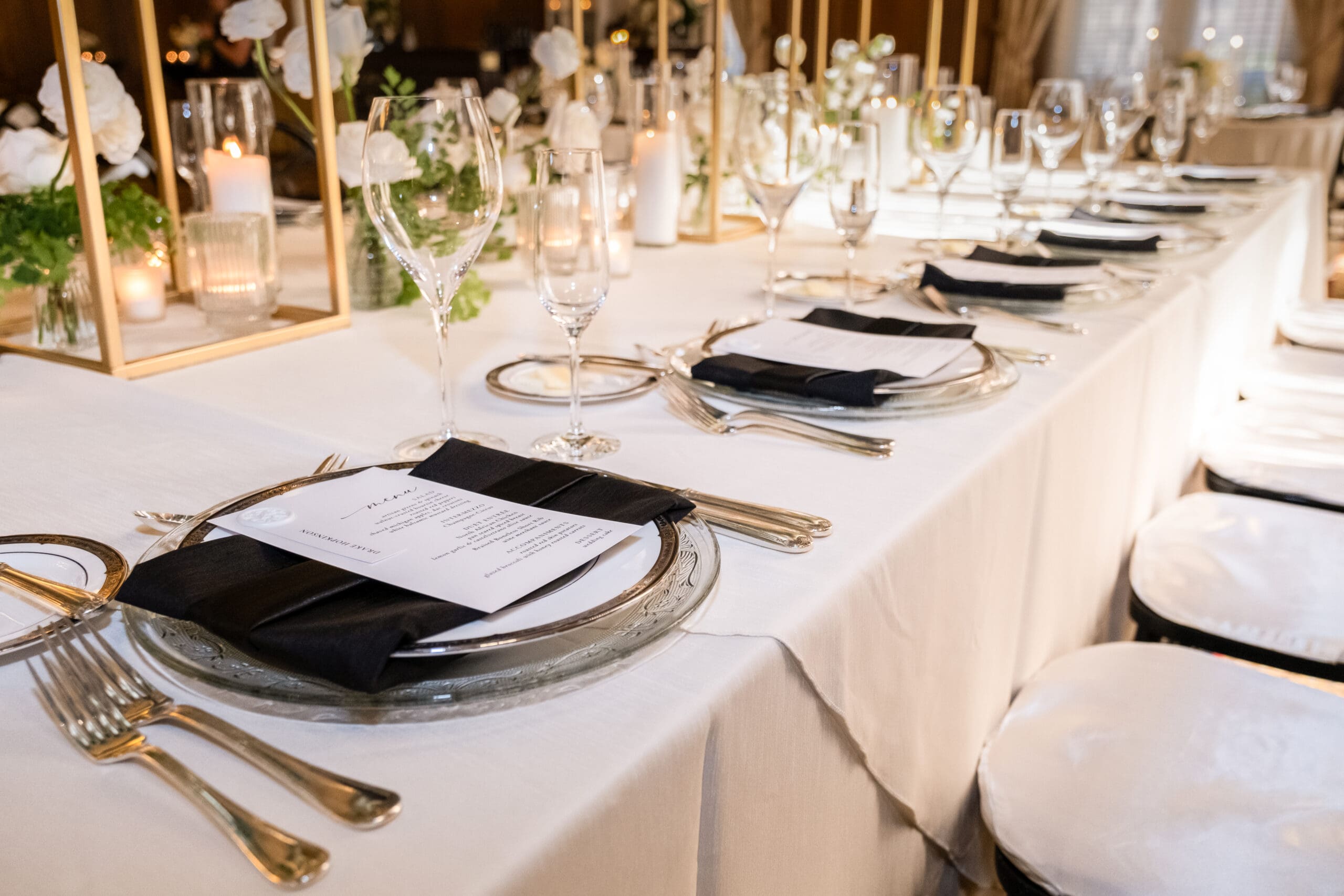 Elegant wedding reception table setting with candles, place settings, and floral decorations