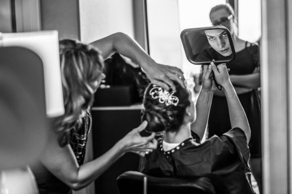 Bride adjusting her hair while getting ready during the wedding morning