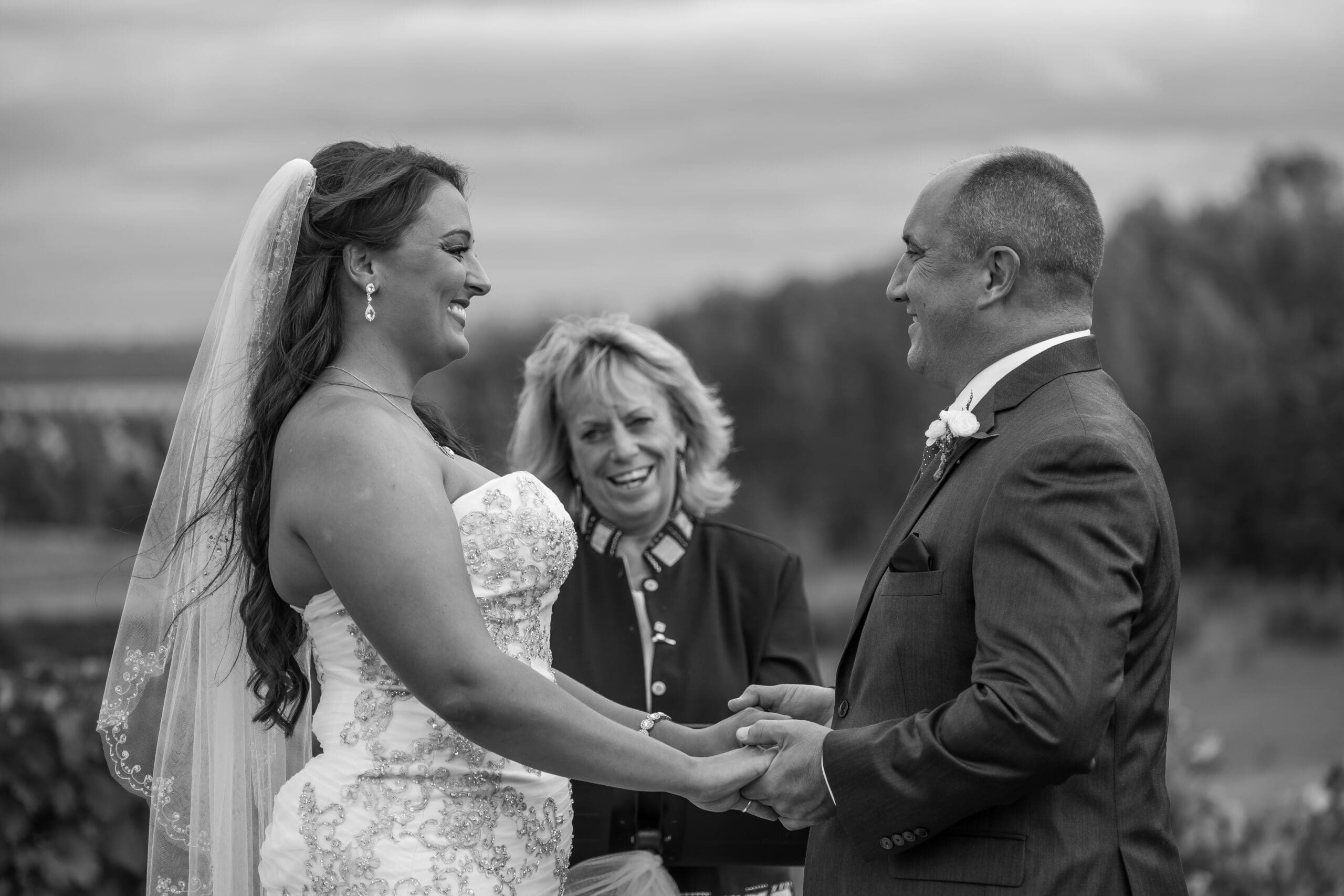 couple standing under an arch during an outdoor ceremony