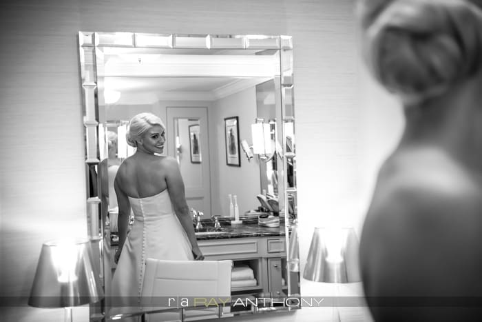Bride looking in a mirror while getting ready for her wedding day.