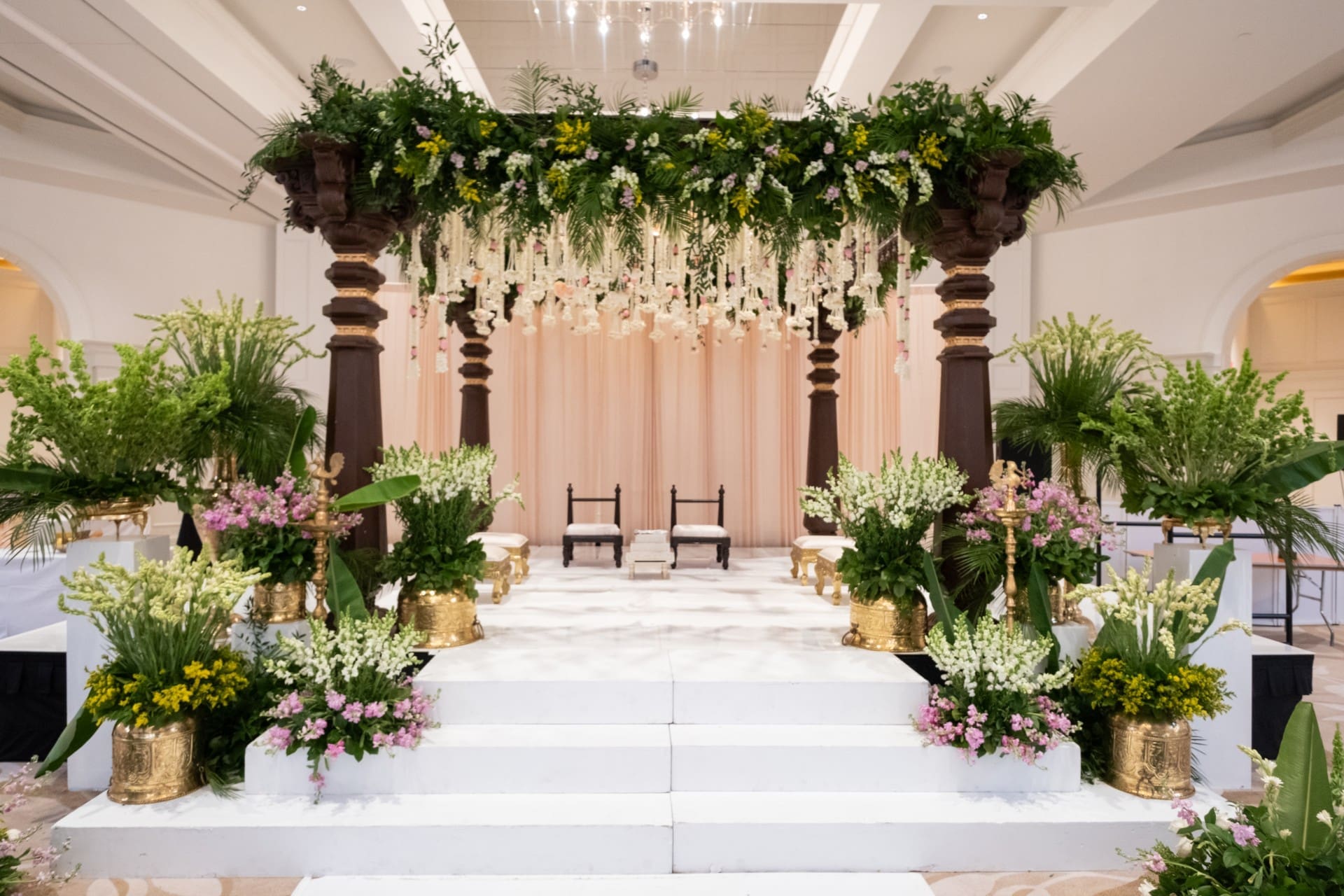 Floral wedding mandap inside Monarch Ballroom at Saint John's Resort featuring cascading greenery, elegant flower arrangements, and a luxury Indian wedding ceremony design.