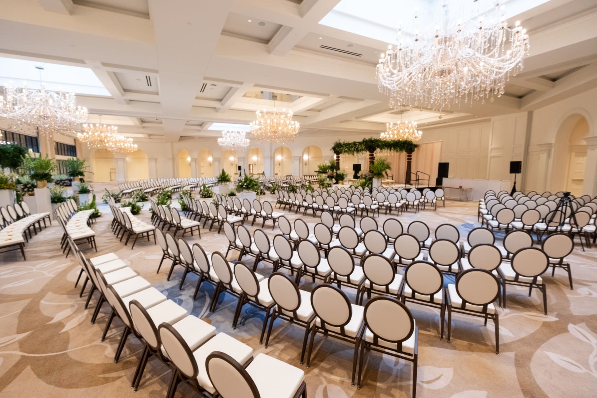 Wide view of Monarch Ballroom at Saint John's Resort prepared for a large wedding ceremony, featuring crystal chandeliers, elegant seating arrangements, and a spacious event layout.