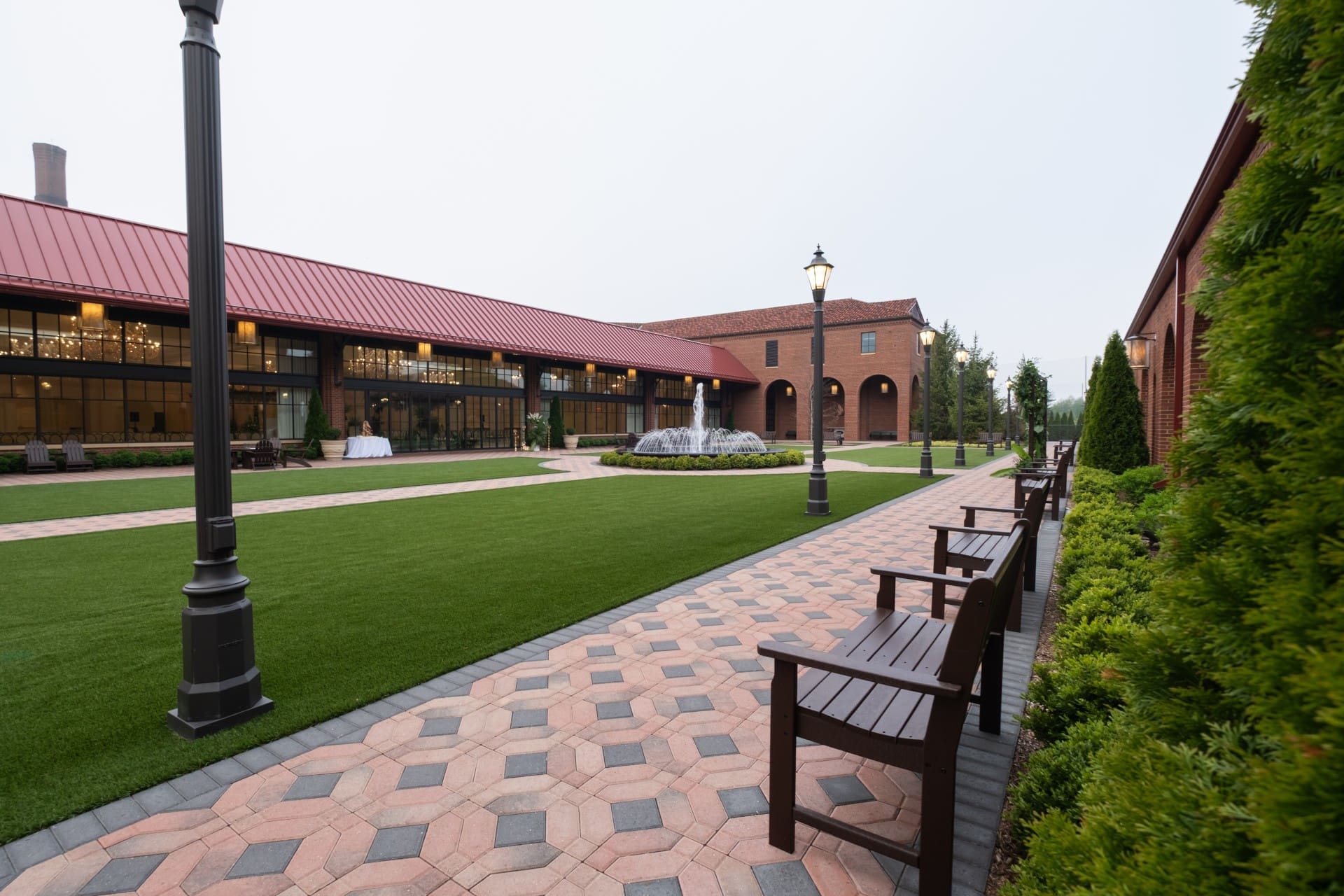 Landscaped courtyard at Saint John's Resort featuring outdoor seating, brick walkways, manicured lawns, and a central fountain in Plymouth, Michigan.