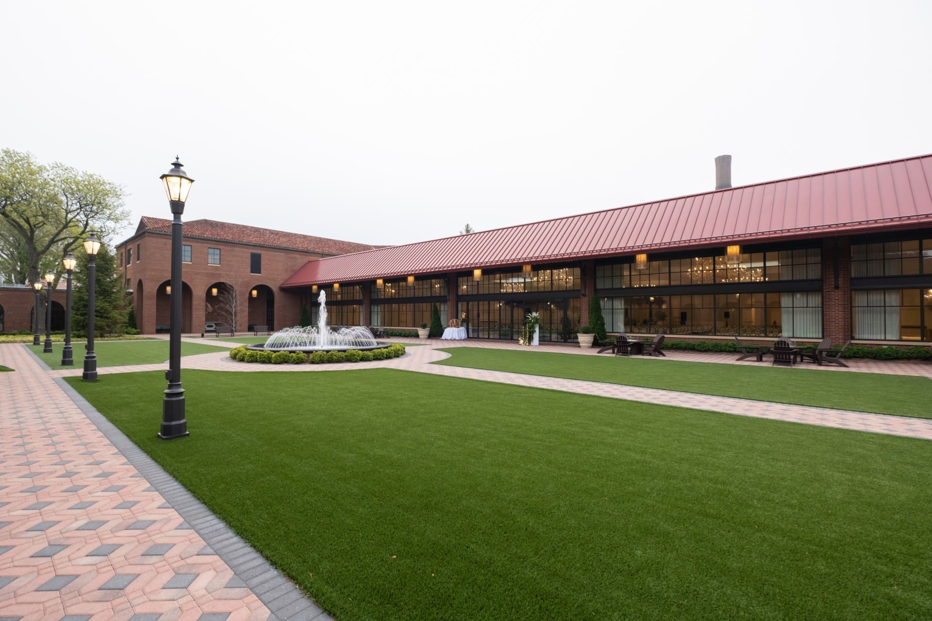 Exterior courtyard at Saint John's Resort featuring landscaped lawns, a central fountain, elegant walkways, and outdoor event spaces in Plymouth, Michigan.