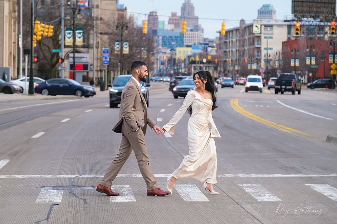 Stylish couple walking through downtown Detroit during an engagement photo session.