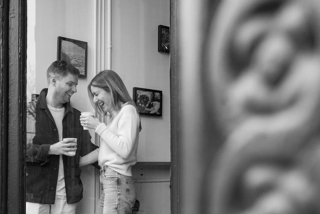 Couple enjoying coffee together during a relaxed Detroit engagement photo session.