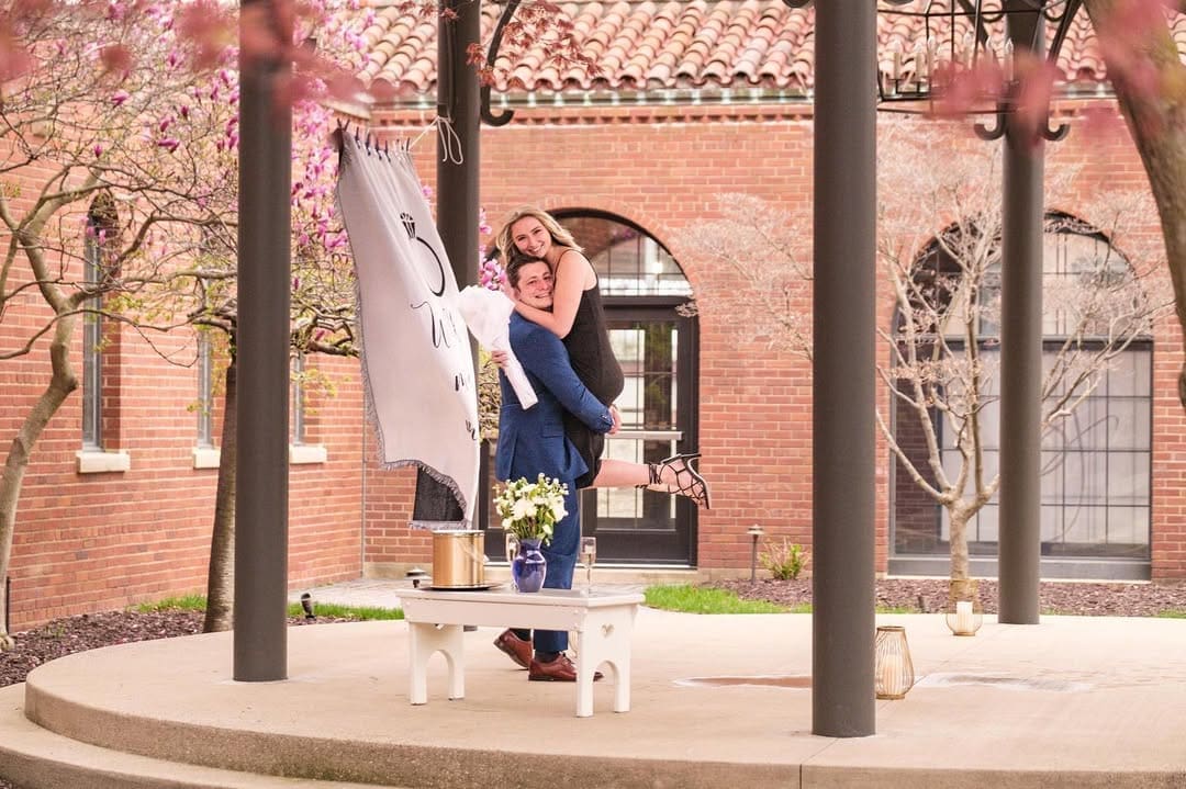 Couple celebrating their Detroit proposal in coordinated spring engagement photo outfits.