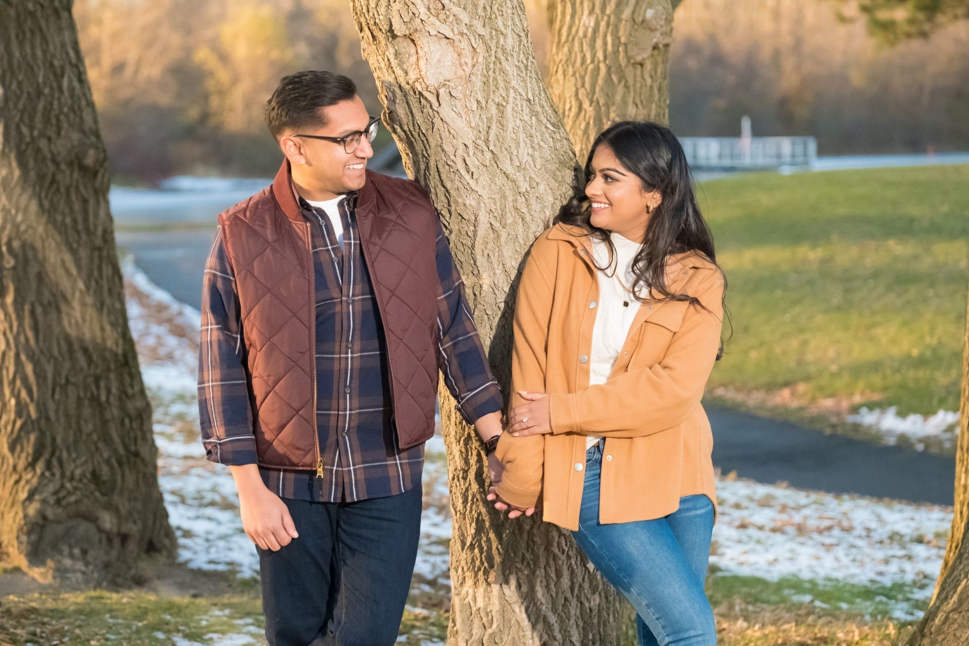 Couple sharing a candid moment beneath a tree during a Detroit engagement session.