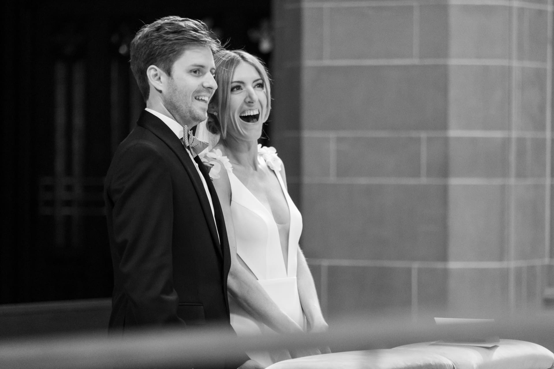 Bride and groom laughing together outside their Detroit wedding venue.