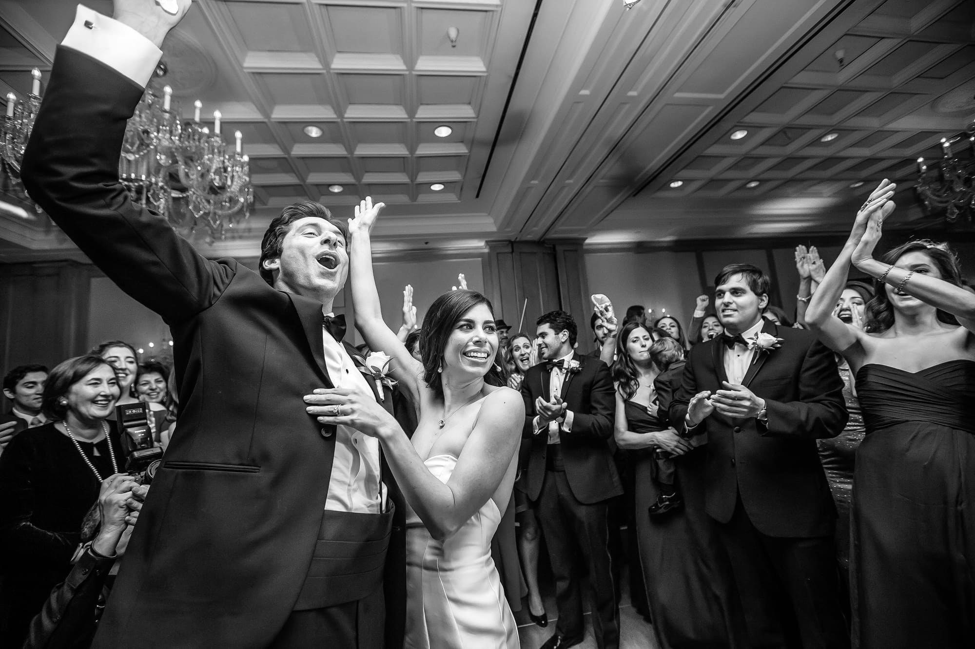 Bride and groom celebrating with wedding guests on the dance floor during a Michigan wedding reception captured through documentary wedding photography