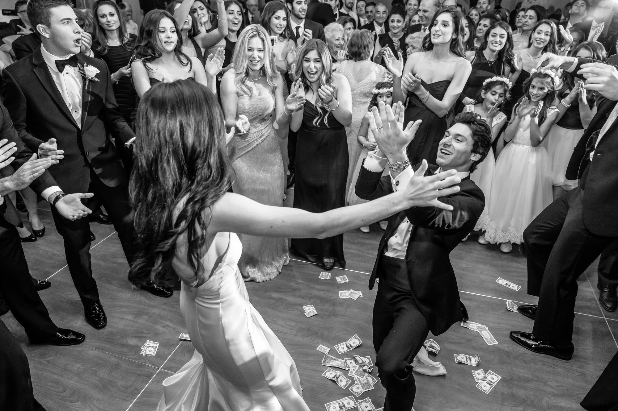 Bride and groom sharing their first dance during a lively Michigan wedding reception captured through documentary wedding photography