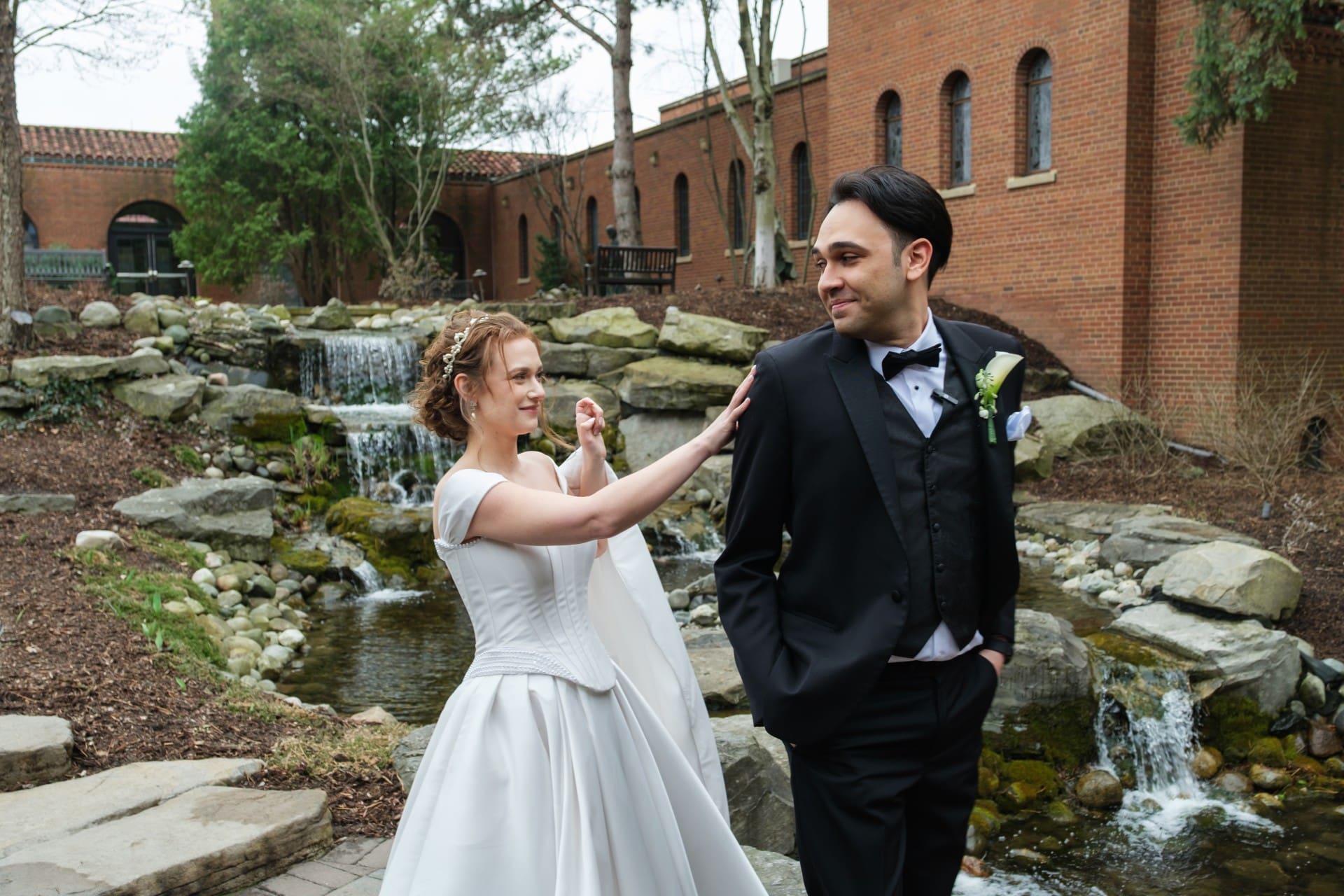 Bride and groom sharing a quiet moment beside a garden walkway