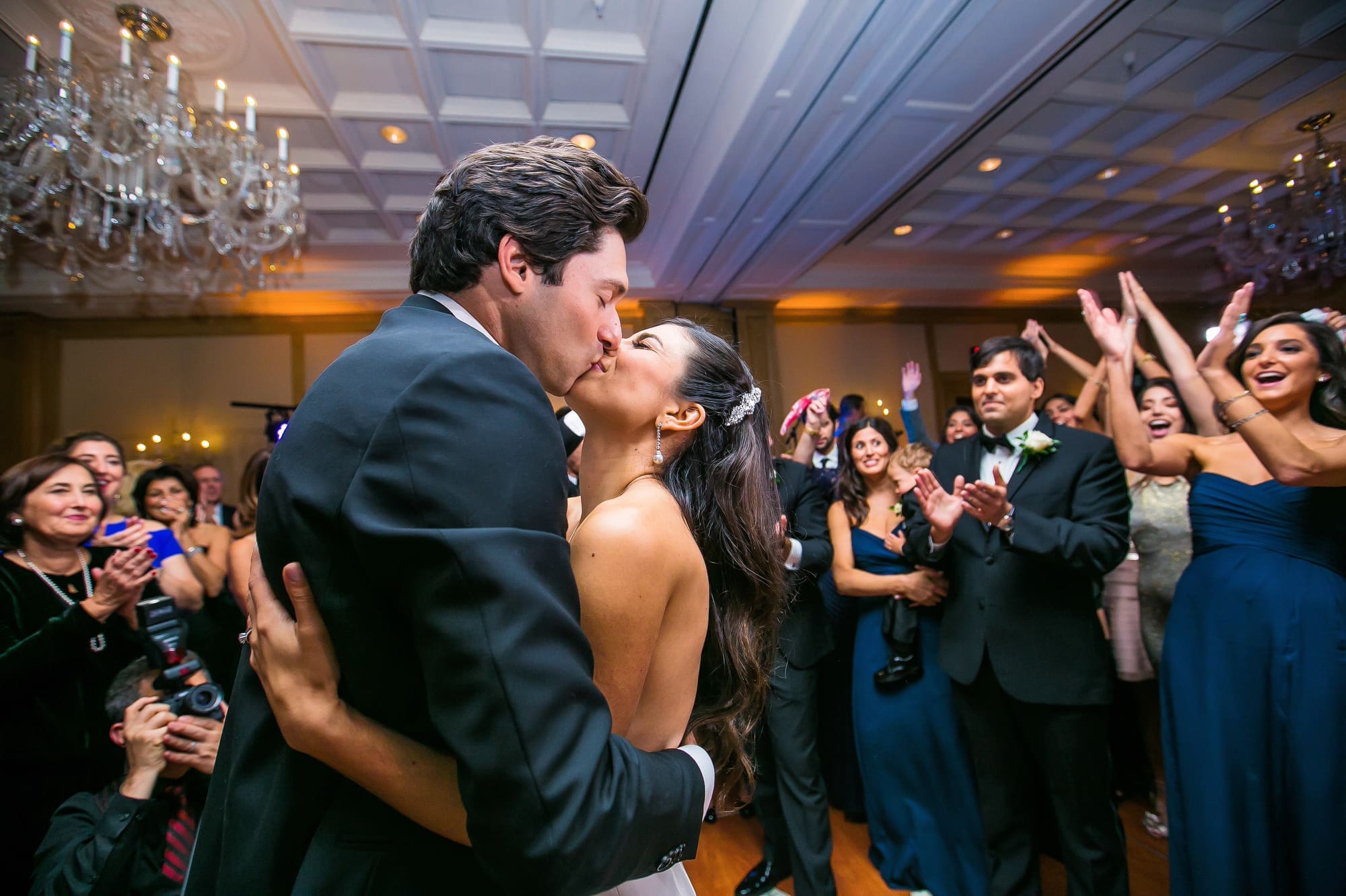 Bride and groom sharing a kiss on the dance floor during a Michigan wedding reception captured through documentary wedding photography