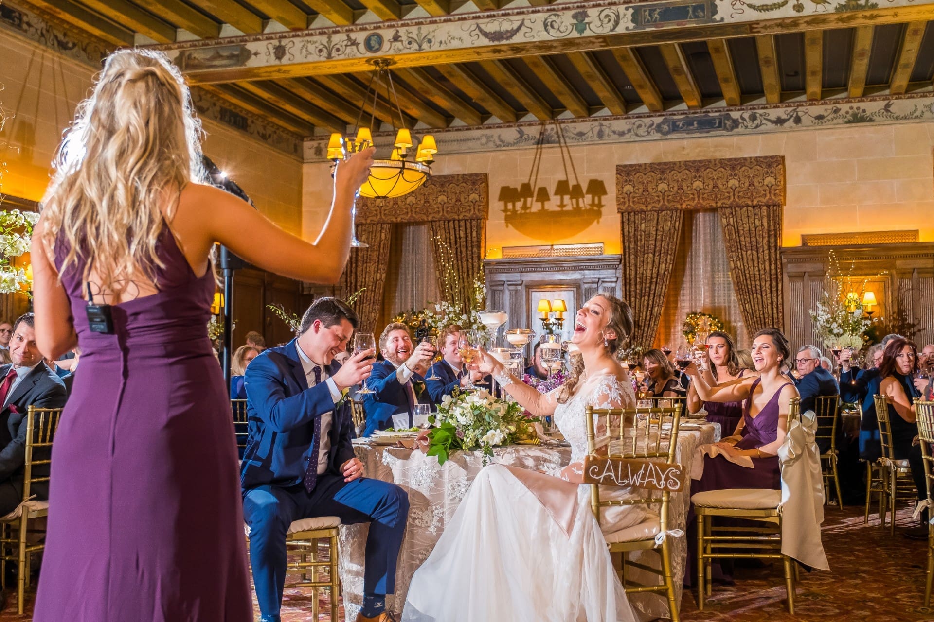 Bride and groom raising champagne glasses with friends and family