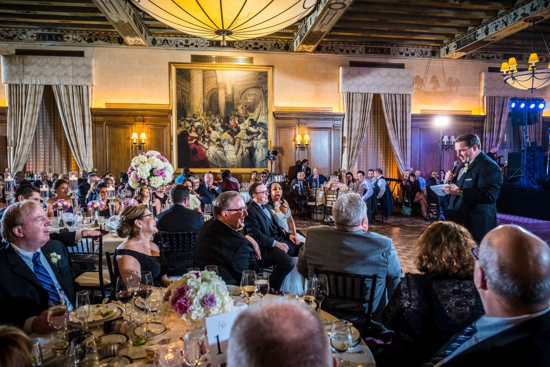 Guest giving a speech while friends and family listen from their tables