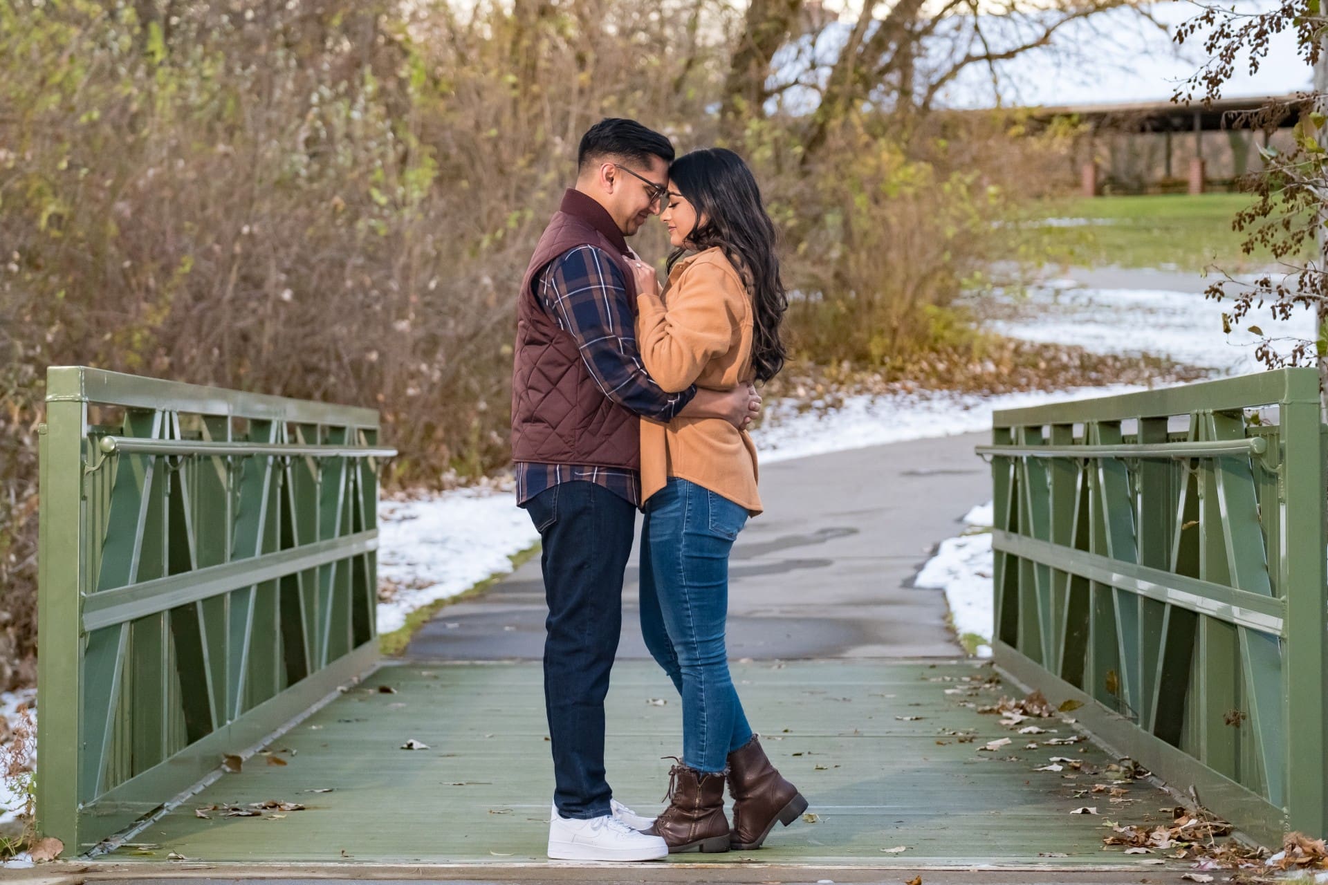 Couple kissing on a bridge during a natural proposal in Michigan
