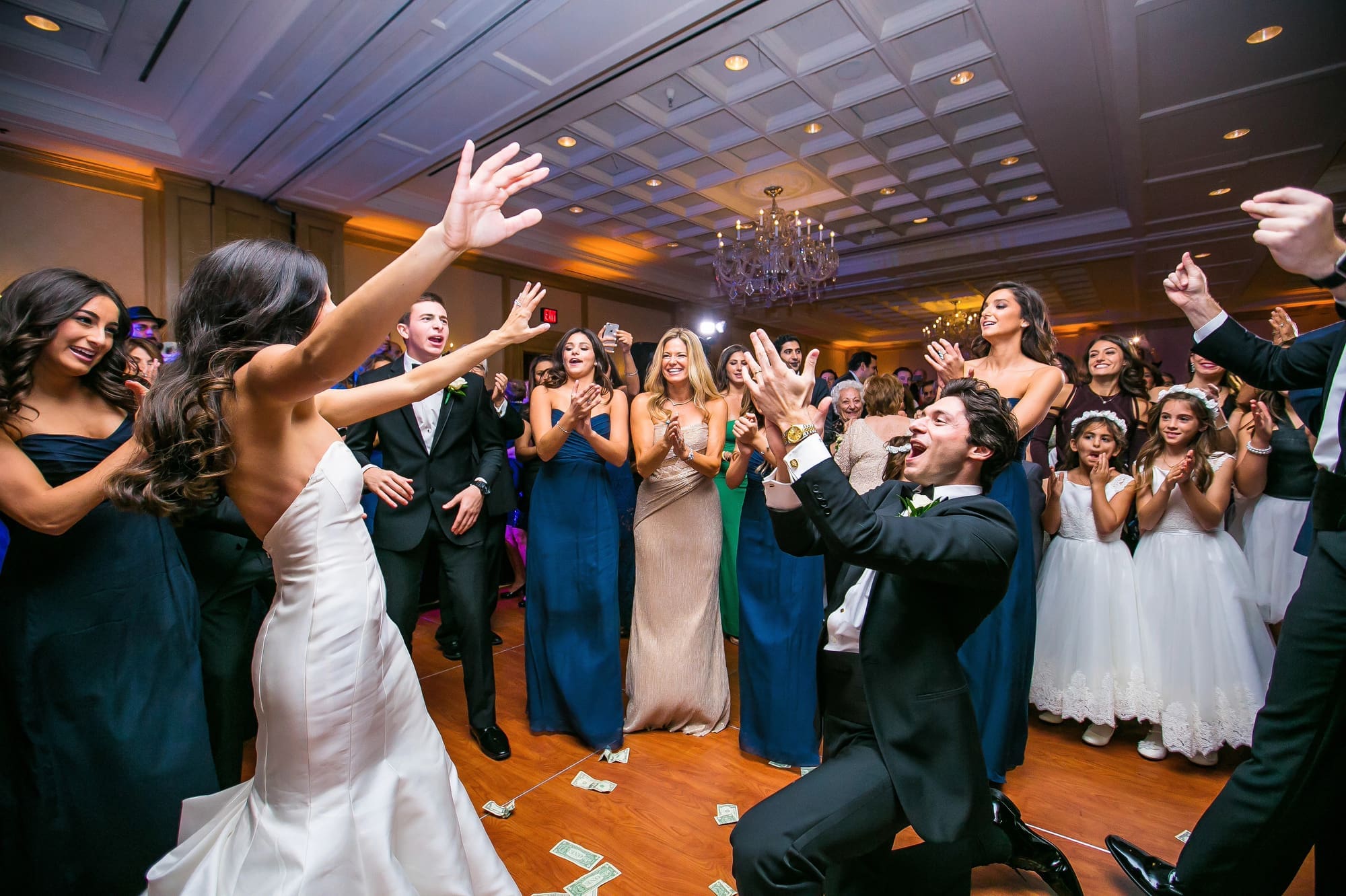 Bride celebrating with wedding guests on a packed dance floor during a Michigan wedding reception captured through documentary wedding photography