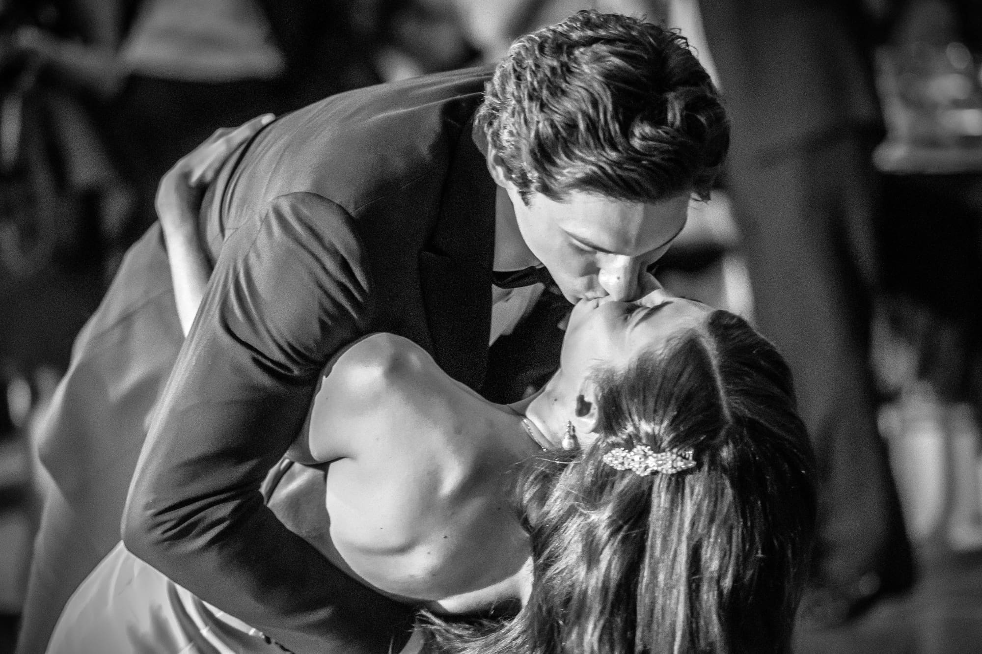 Bride and groom sharing a romantic dip on the dance floor during a Michigan wedding reception captured through documentary wedding photography