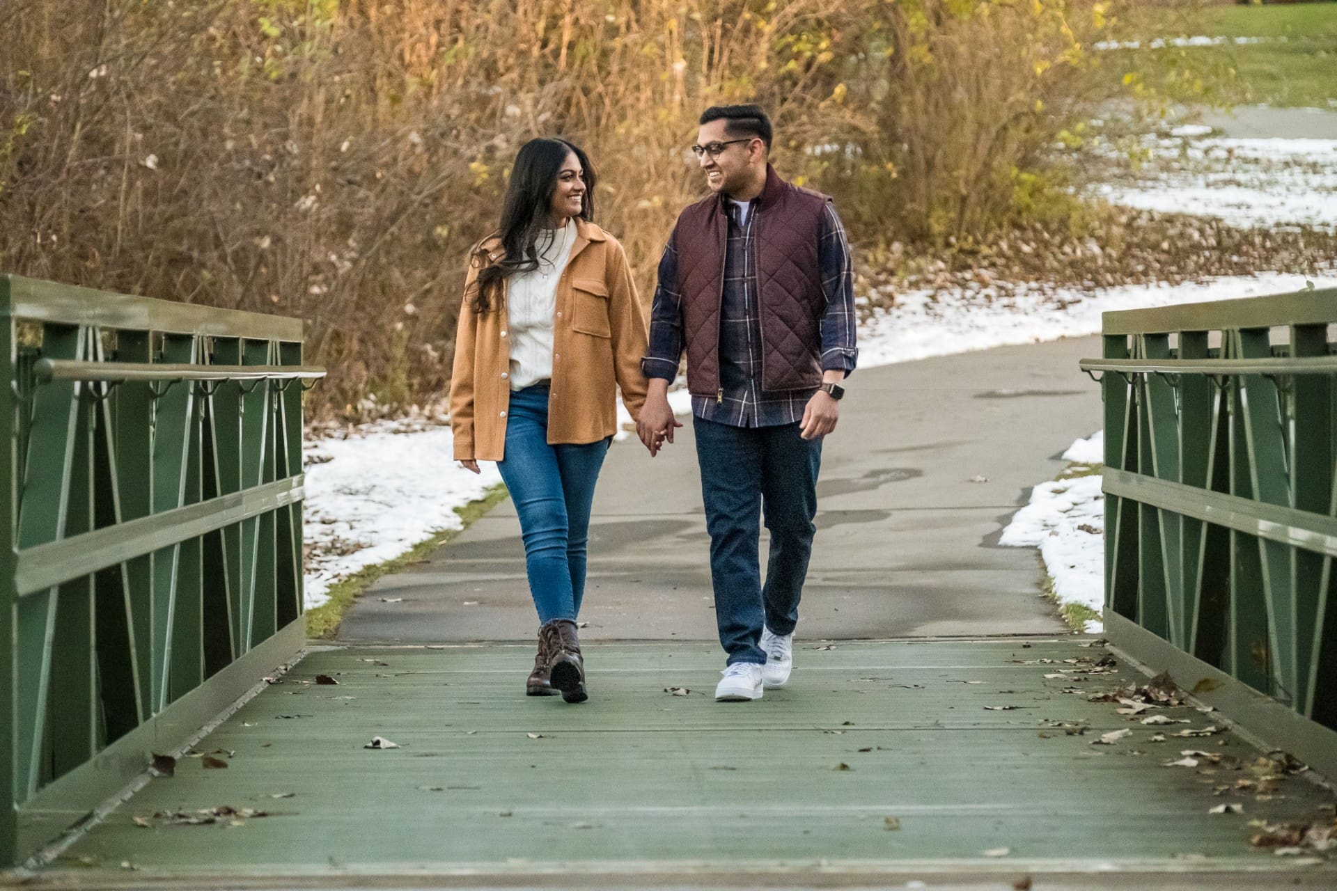 Couple walking together across a wooden bridge