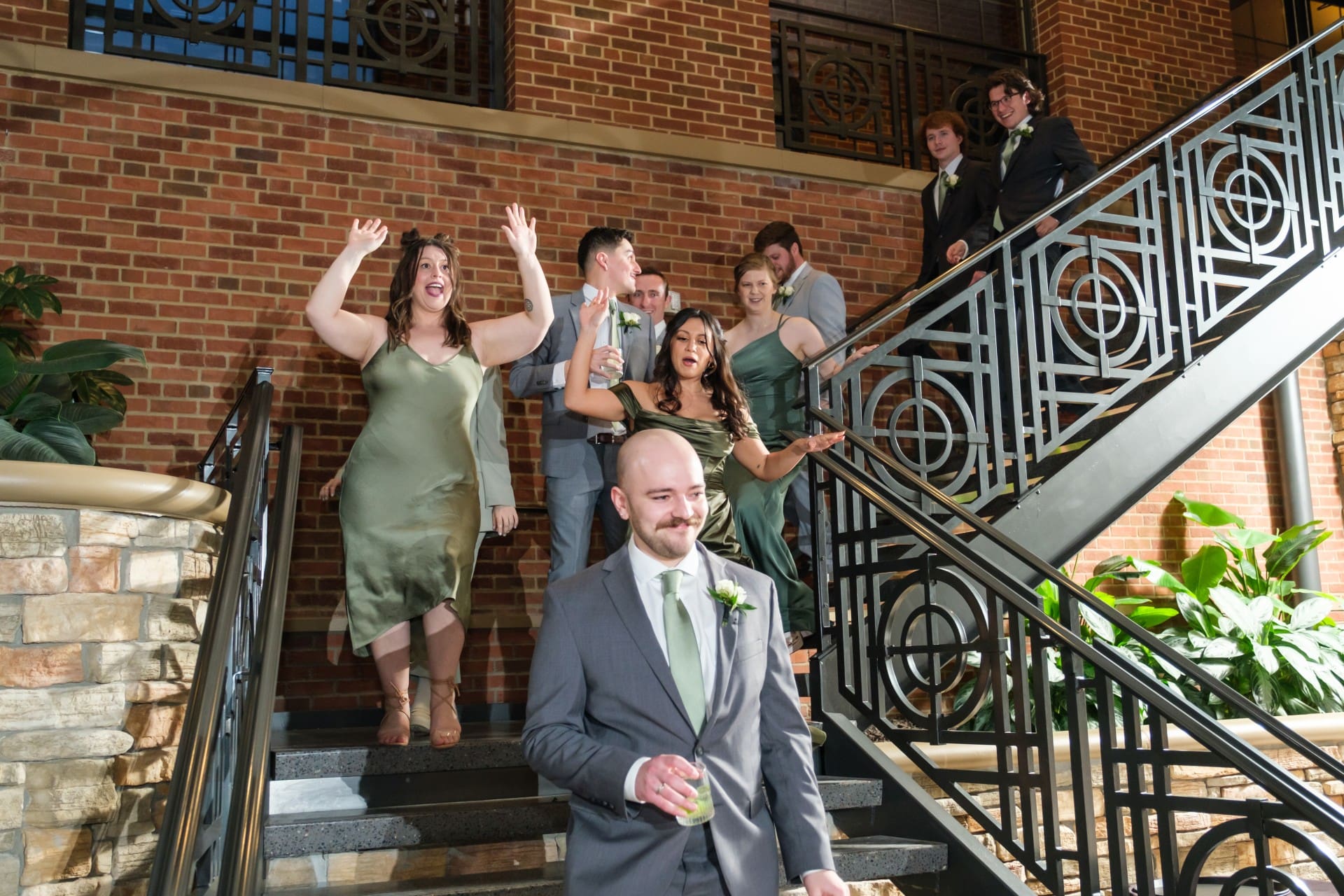 Wedding party celebrating together on the stairs at St. John’s Resort in Plymouth, Michigan
