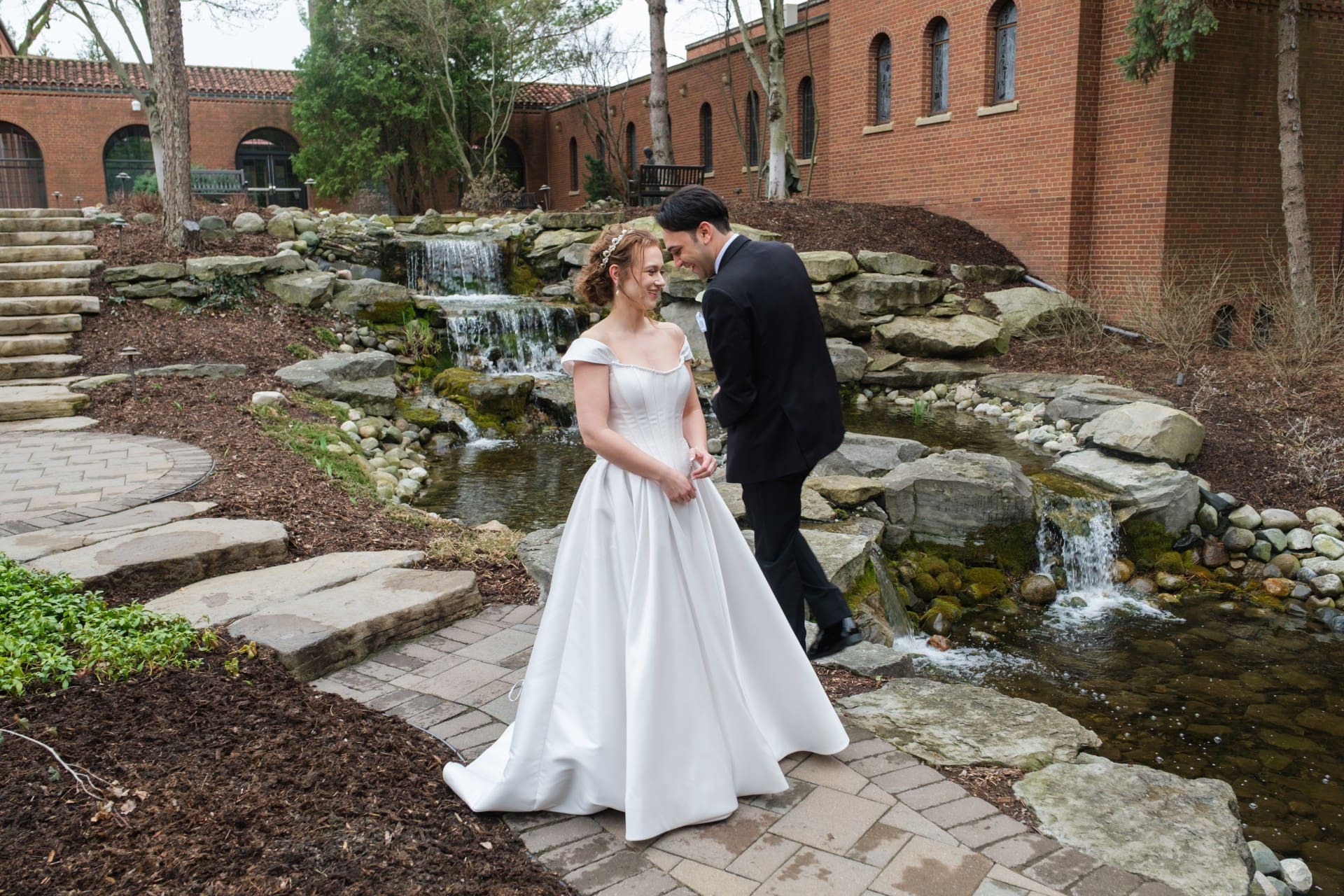 Bride and groom talking outdoors near a brick wedding venue