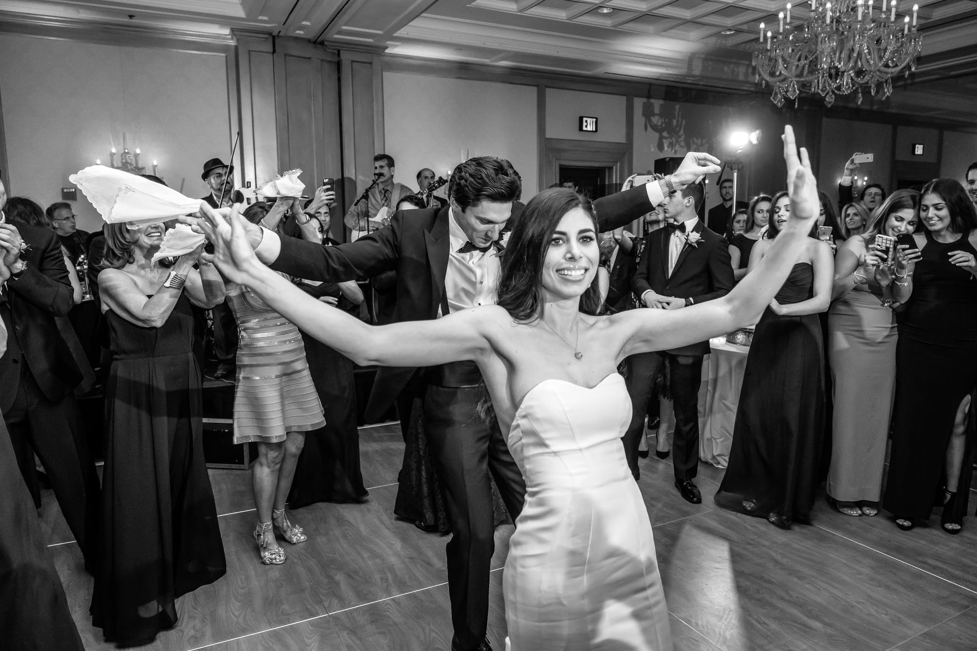 Wedding guests dancing naturally during a lively Michigan wedding reception captured through documentary wedding photography