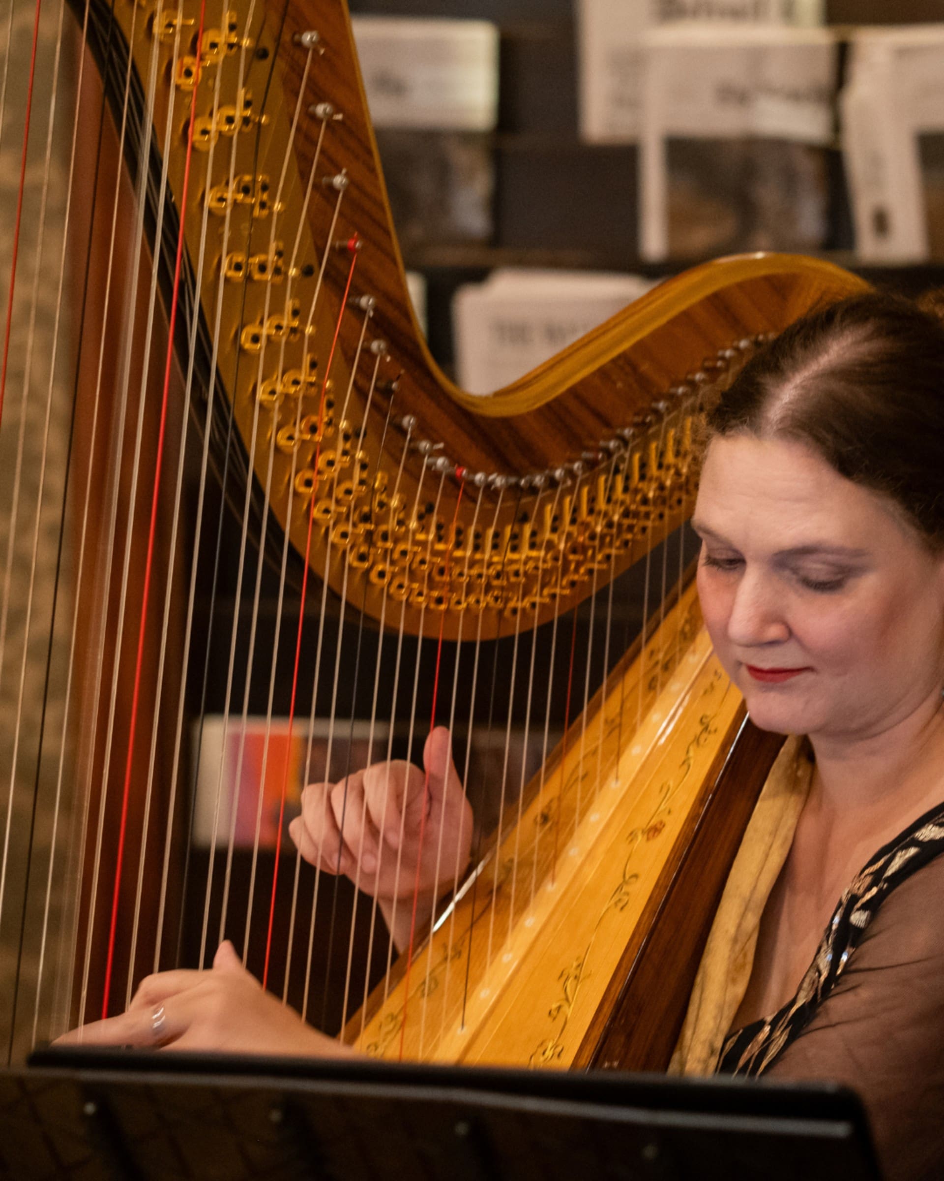 Close-up of a harpist playing a golden harp during the Chang 50th Anniversary celebration