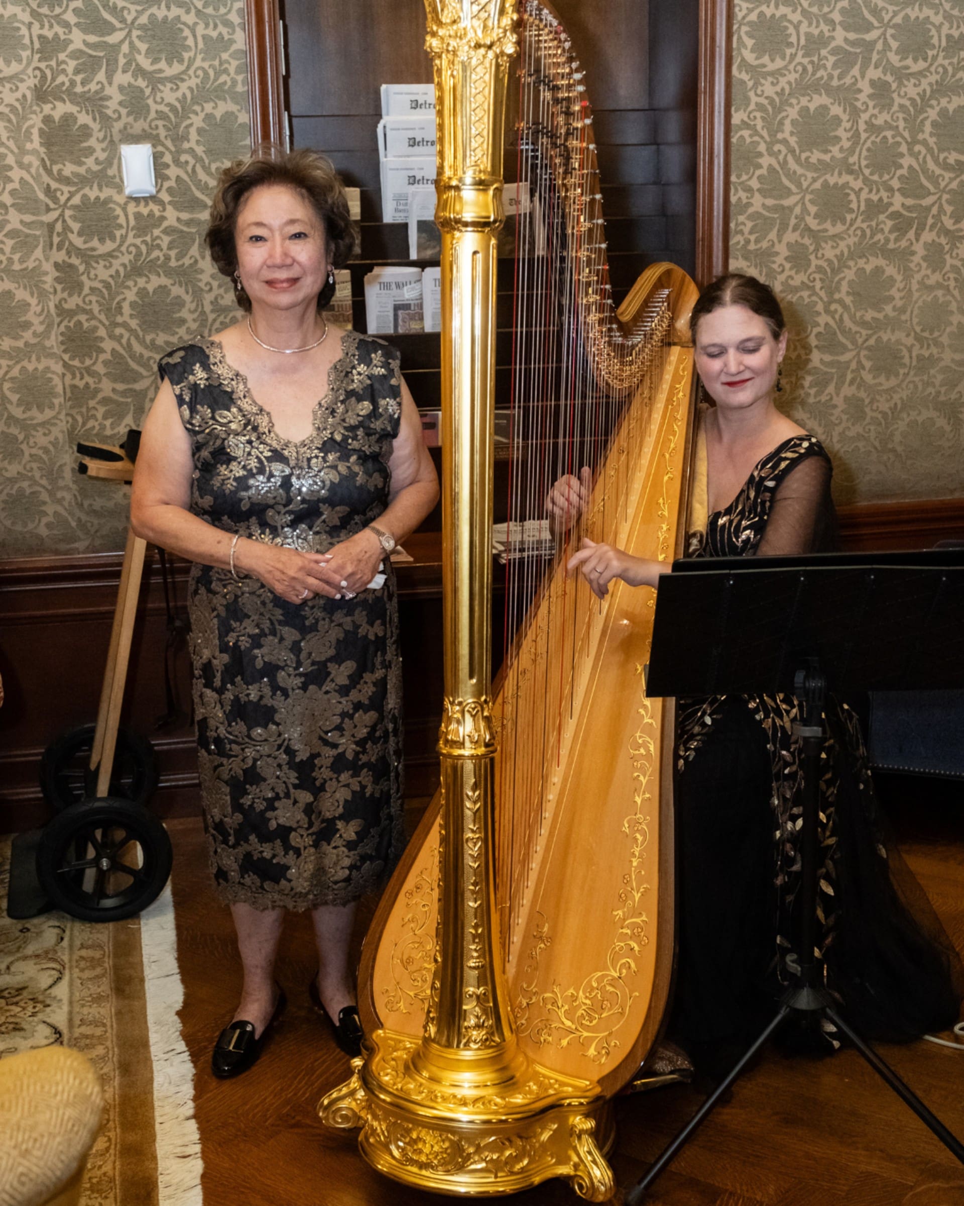 Harpist performing beside a guest during the Chang 50th Anniversary celebration at the Detroit Athletic Club