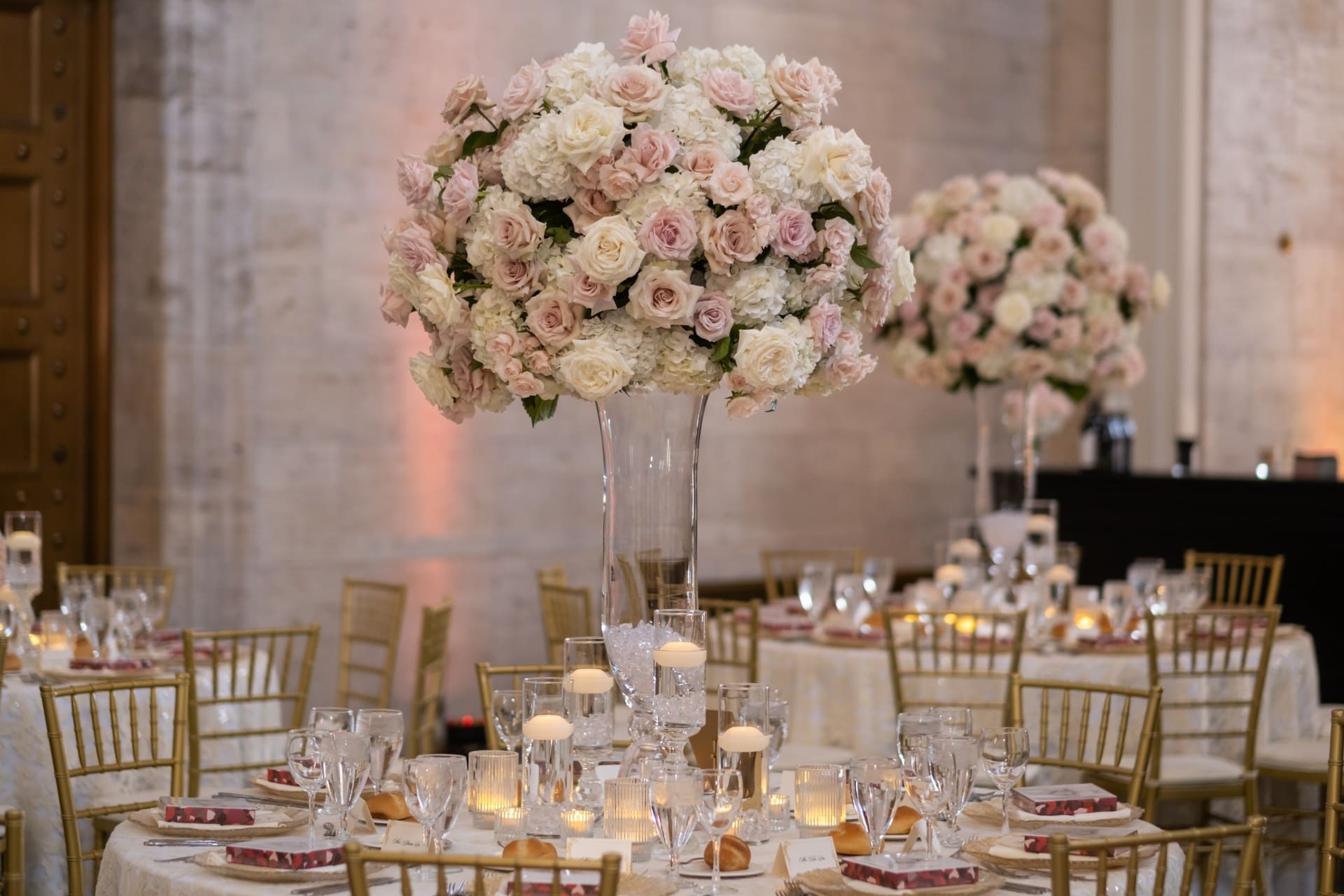 Elegant blush floral centerpiece with gold chairs and table settings at the Chang 50th Anniversary