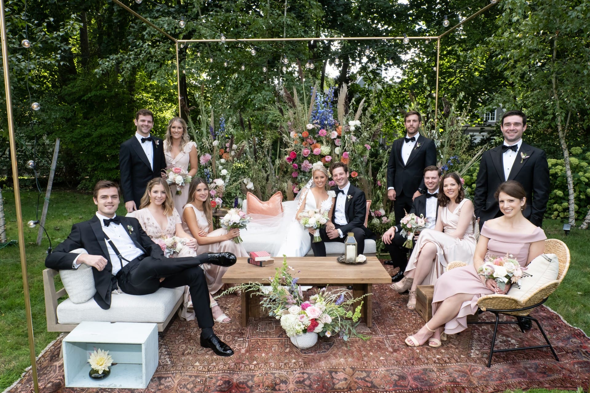 Bride and groom celebrating with their wedding party in a garden reception setting