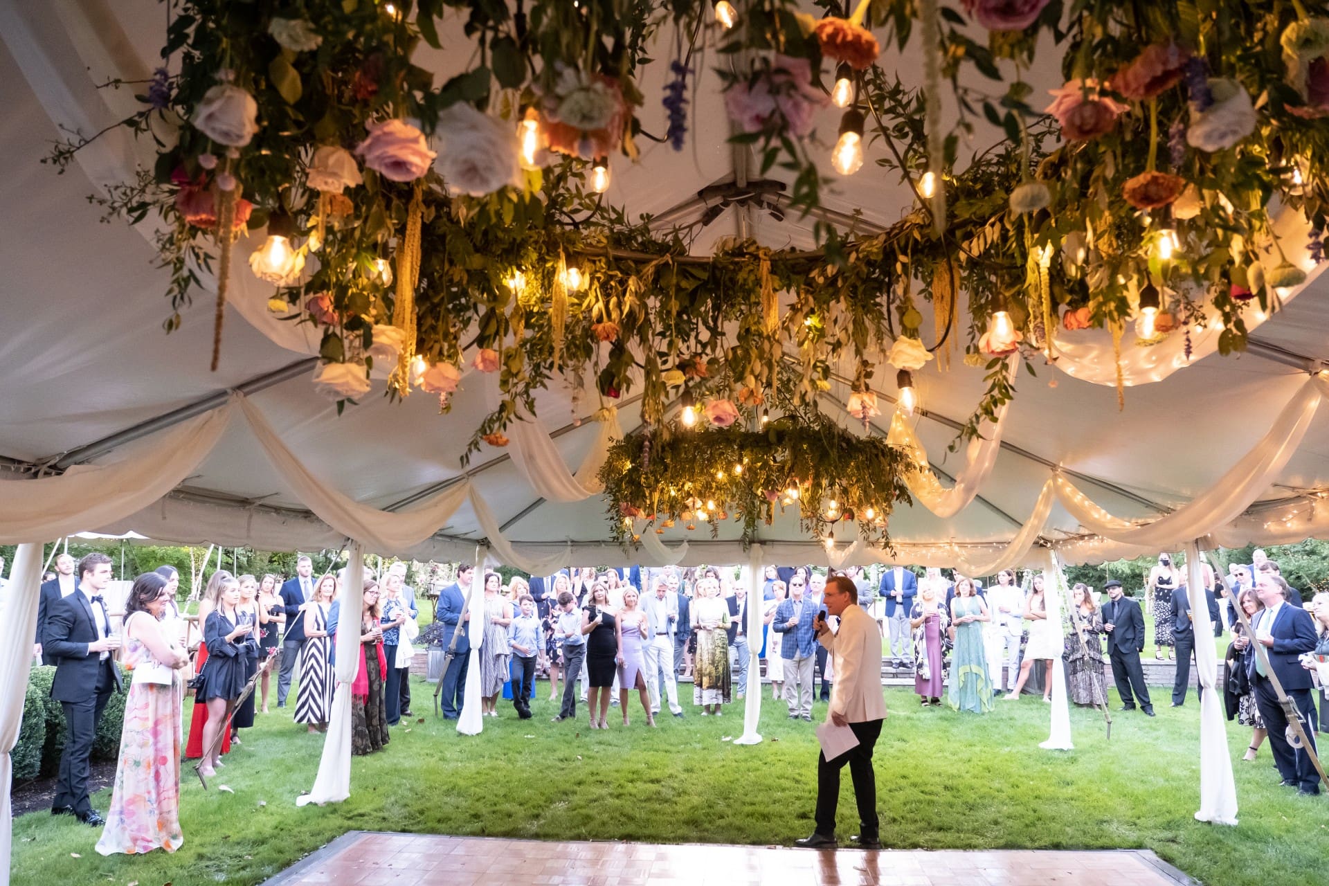 Bloomfield Hills wedding reception beneath a floral canopy with guests gathered outdoors