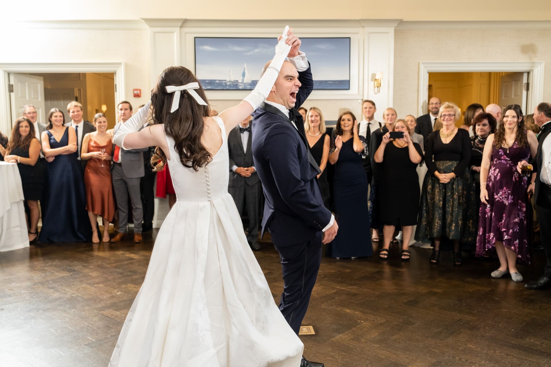 Bride and groom dancing together with wedding guests in an elegant venue