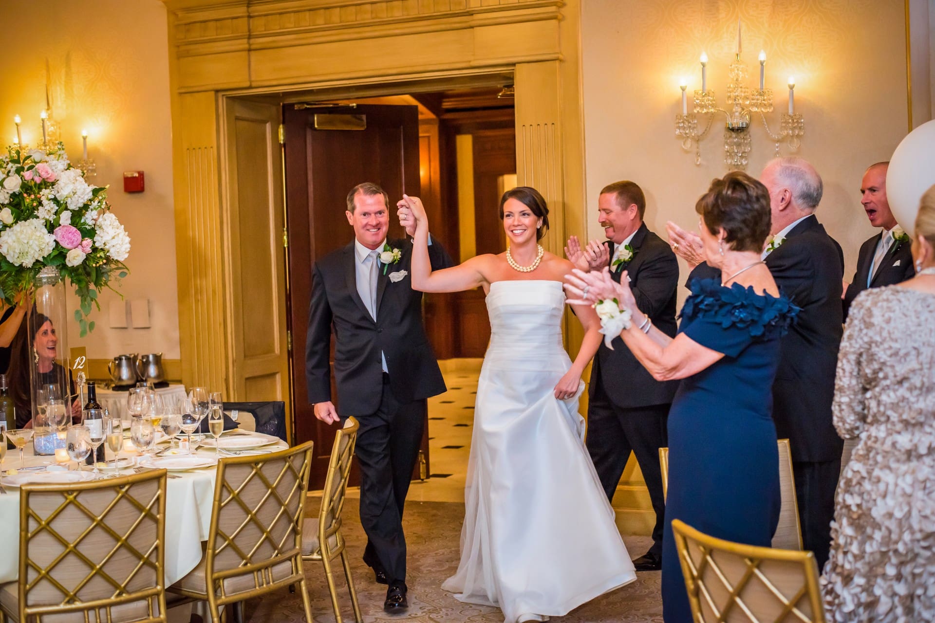 Bride and groom celebrating with family and friends in an elegant wedding venue