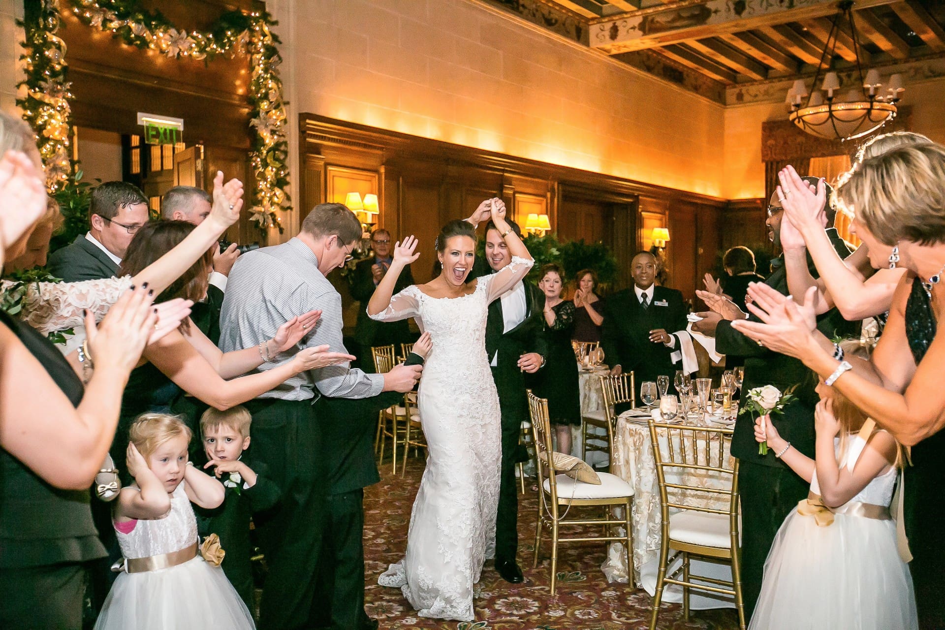 Bride and groom celebrating with guests inside a beautifully decorated wedding venue